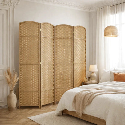 Paravent en rotin à quatre panneaux dans une chambre avec un lit et une lampe