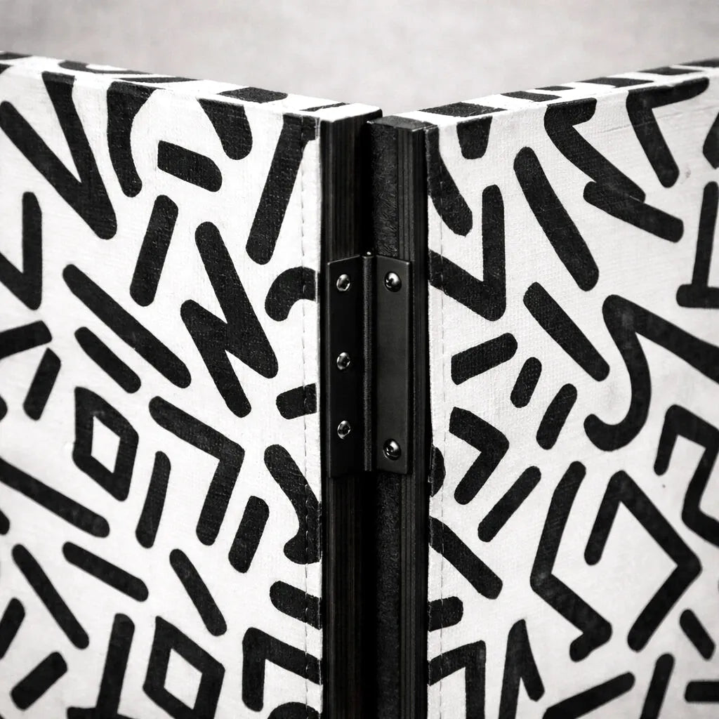 Charnière noire sur un paravent blanc à motifs géométriques noirs